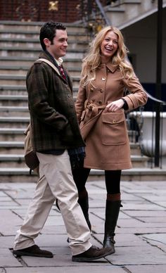 a man and woman are walking down the street smiling at each other while holding hands