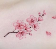 a close up of a tattoo with pink flowers on it