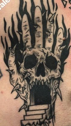 a man with a tattoo on his back has a skull in the shape of a hand