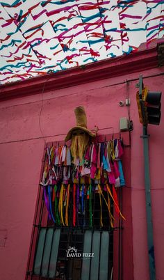 a pink building with colorful streamers hanging from it's side and a straw hat on top