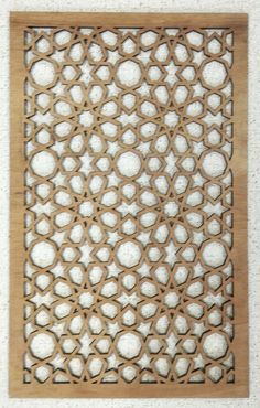 an intricate wooden panel with holes in the middle and white circles on it's surface