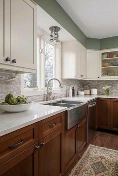 a kitchen with wooden cabinets and white counter tops, along with an area rug on the floor