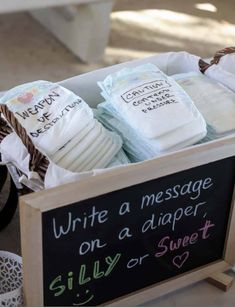 several diapers are in a basket on the floor next to a sign that says write a message on a diaper, silly or sweet