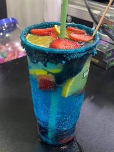 a blue drink with strawberries and lemons in it sitting on a counter top