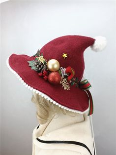 a woman wearing a red hat with christmas decorations on it