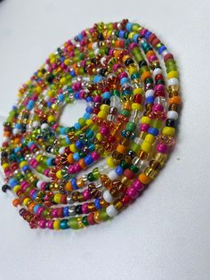 Brighten your life and wardrobe with our stunning Multicolored Waistbead. Handcrafted with love, each bead is carefully selected and strung to create a vibrant, eye-catching accessory that complements any outfit. Uses of the Multicolored Waistbead: • Fashion Statement: Wear it over or under your clothing to add a pop of color and a touch of elegance to your ensemble. • Body Awareness: Helps you stay mindful of your body, serving as a gentle reminder of your fitness and wellness journey. • Weight Bohemian Colorful Spacer Beads, Colorful Bohemian Spacer Beads, Adjustable Multicolor Beaded Chain Waist Beads, Bohemian Multicolor Beaded Bracelets, Multicolor Beaded Chain Waist Beads For Festivals, Spiritual Multicolor Round Waist Beads, Spiritual Multicolor Waist Beads With Tiny Beads, Adjustable Large Multicolor Beads, Colorful Vibrant Beaded Bracelets