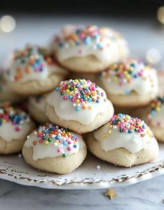 a white plate topped with cookies covered in frosting and sprinkles on top of a table