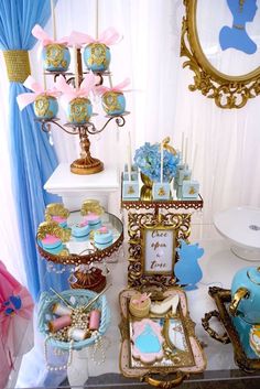 a table topped with lots of blue and gold items on top of a white table