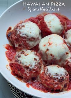 a white bowl filled with meatballs covered in marinara sauce on top of a table