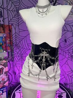 Elevate your style with this edgy Y2K-inspired corset belt, featuring a captivating punk aesthetic. Adorned with intricate cross charms and a bold heart design, this statement piece effortlessly combines rebellious flair with a touch of romance. The belt is enhanced with eye-catching chains that add an extra layer of attitude. Crafted for comfort and versatility, the back of the corset belt is equipped with a convenient Velcro closure. The elastic material provides just the right amount of stret Edgy Festival Corset For Halloween, Edgy Halloween Festival Corset, Gothic Chain Belt For Party, Punk Party Corset, Edgy Halloween Corset For Alternative Fashion, Edgy Black Chain Belt For Festival, Alternative Style Halloween Corset For Concerts, Halloween Corset For Concert, Punk Halloween Corset For Concerts