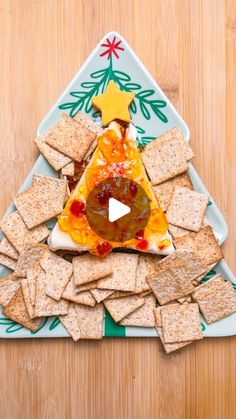 a christmas tree made out of crackers and cheese on a plate with a video