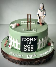 a birthday cake with a cricket theme on the side and a figurine standing next to it