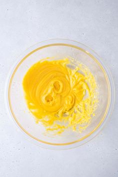 a bowl filled with yellow liquid on top of a white table