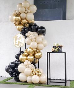 black and gold balloons are stacked on top of each other