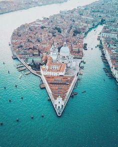 an aerial view of venice, italy in the middle of the ocean with boats and buildings around it