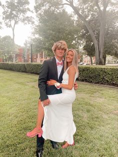 a man in a tuxedo is hugging a woman