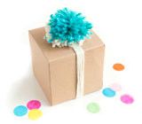 a brown box with a blue pom - pom on top and confetti around it