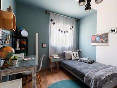 a bedroom with blue walls and wooden floors