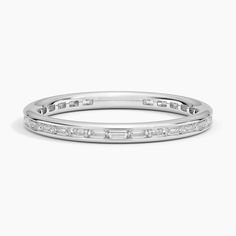 a white gold wedding band with baguetts and diamonds on the side, set in 18k white gold