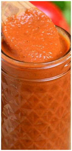 a spoon full of tomato sauce in a jar