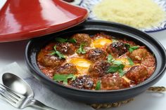 a bowl filled with meatballs and eggs on top of a table next to rice