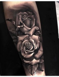 a black and white rose tattoo on the leg