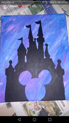 the silhouette of mickey mouse is painted on a piece of paper with blue and purple paint