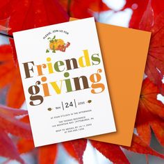 an orange and white card with the words friends giving on it next to some red leaves