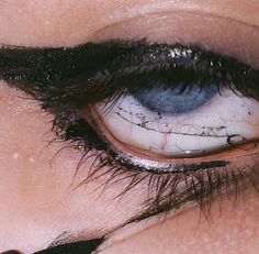 an eye with black and white makeup on it