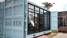 a blue shipping container with the words bar beer on it's side and a pair of scissors in its window