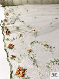 an embroidered table cloth with flowers on it