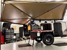 an off road camper is parked in a garage