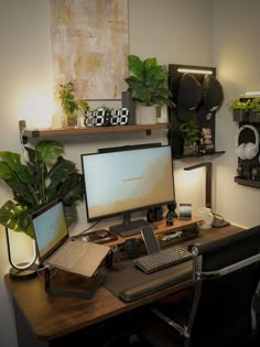 a desk with a computer and some plants on it