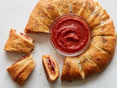 an assortment of pastries on a white surface with a red sauce in the middle