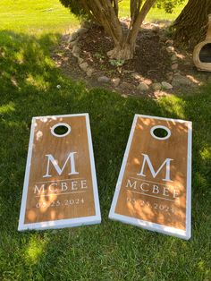 two cornhole game boards sitting in the grass