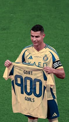 a soccer player holding up a jersey on the field