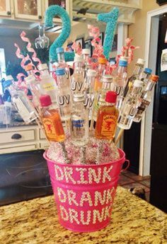 a pink bucket filled with bottles sitting on top of a counter