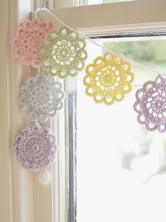 crocheted doily hanging from a window sill