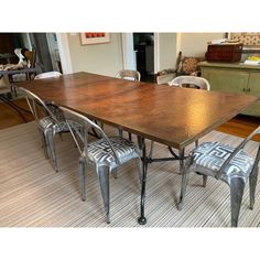 a dining room table with chairs and a rug on the floor