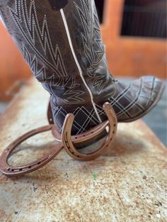 the cowboy boots are tied up on the ground with their heel rings attached to them