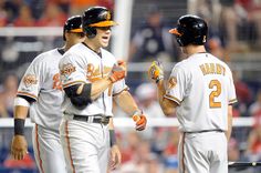 three baseball players standing next to each other in front of a crowd at a game