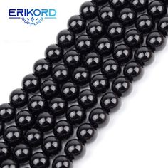 black onyxite beads are lined up against a white background