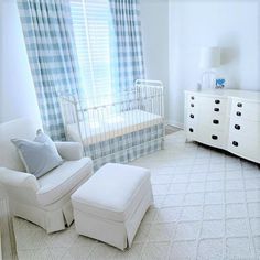 a baby's room with a crib, dresser and chair