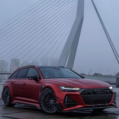 a red car parked in front of a bridge