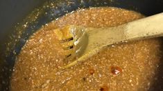 a wooden spoon stirring some food in a pot