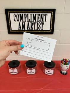 a person holding up a piece of paper with writing on it next to some jars