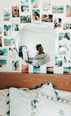 a person taking a selfie in front of a mirror on a wall with pictures