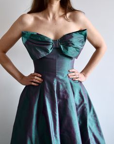 Vintage raw silk strapless ball gown with a huge bow on the front.  An amazing color, I've seen this referred to as diamond green purple, chameleon, or iridescent. Tulle underneath. Comes with a little matching scarf that you can use to cover your shoulders or perhaps tie in your hair.  No size marked. Approximately size 2/4. Measured flat, on the front: 49" long 15" bust 13.5" waist In very good vintage condition. Hook closure on the top has come undone, fully functioning without it as well. There are s couple of tiny white spots on the hem, see last photo. Green Strapless Dress With Sweetheart Neckline For Formal Occasions, Green Strapless Dress For Gala Prom Season, Green Strapless Dress For Gala During Prom Season, Green Strapless Dress For Gala Prom, Green Strapless Evening Dress For Gala, Green Strapless Evening Dress For Prom, Green Evening Dress With Bow, Green Strapless Dress For Prom Evening, Strapless Green Evening Dress For Cocktail