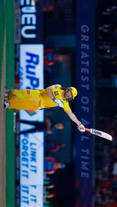 a man in yellow is flying through the air with a baseball bat on his feet