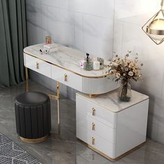 a white and gold vanity with flowers on the counter top next to a black stool